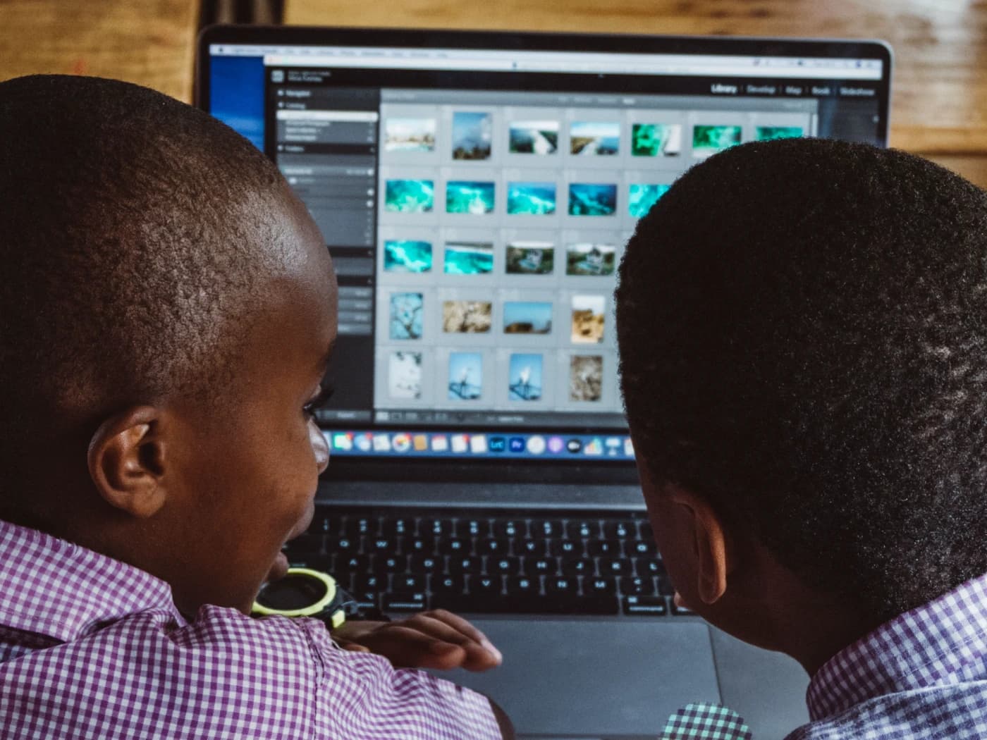 2 students sitting at a table with a laptop in front of them.