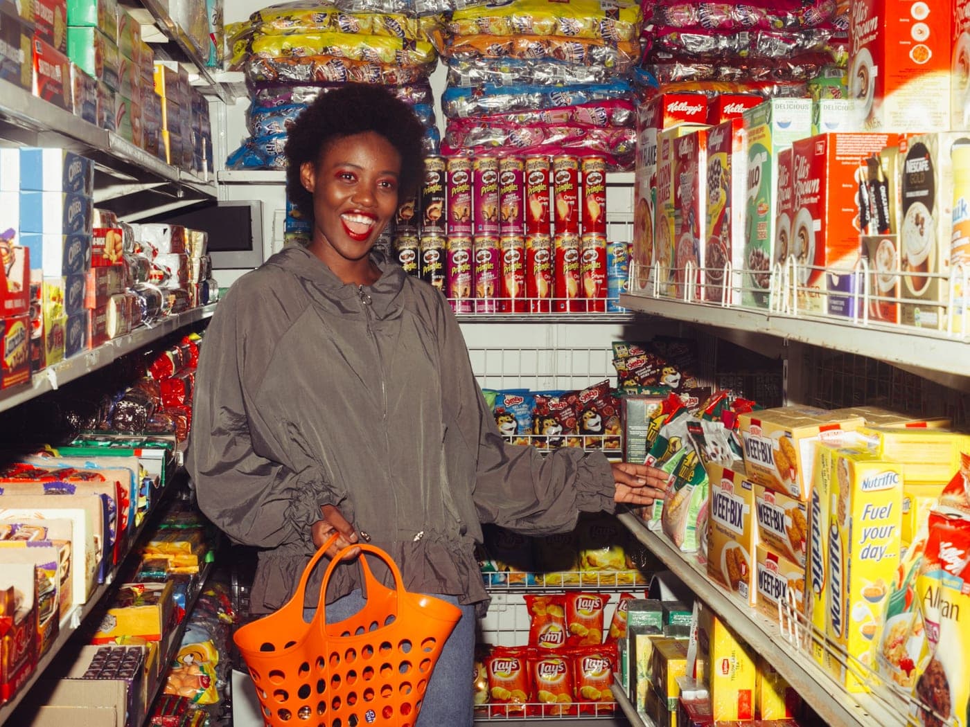 A shopper with a basket in a well-stocked aisle
