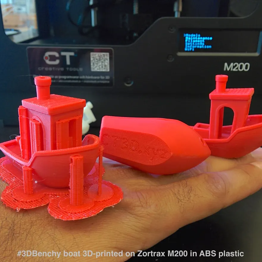 A small black ABS-printed boat model held in a hand
